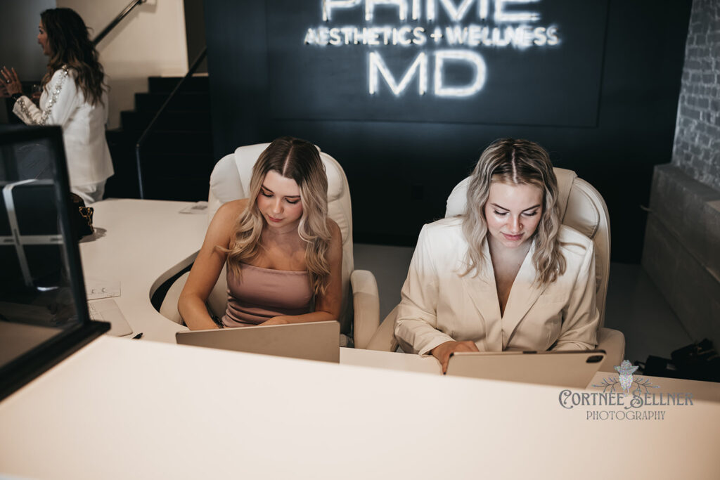 Reception area at Prime MD Johnson City with staff at the front desk and illuminated Prime MD Aesthetics + Wellness sign.